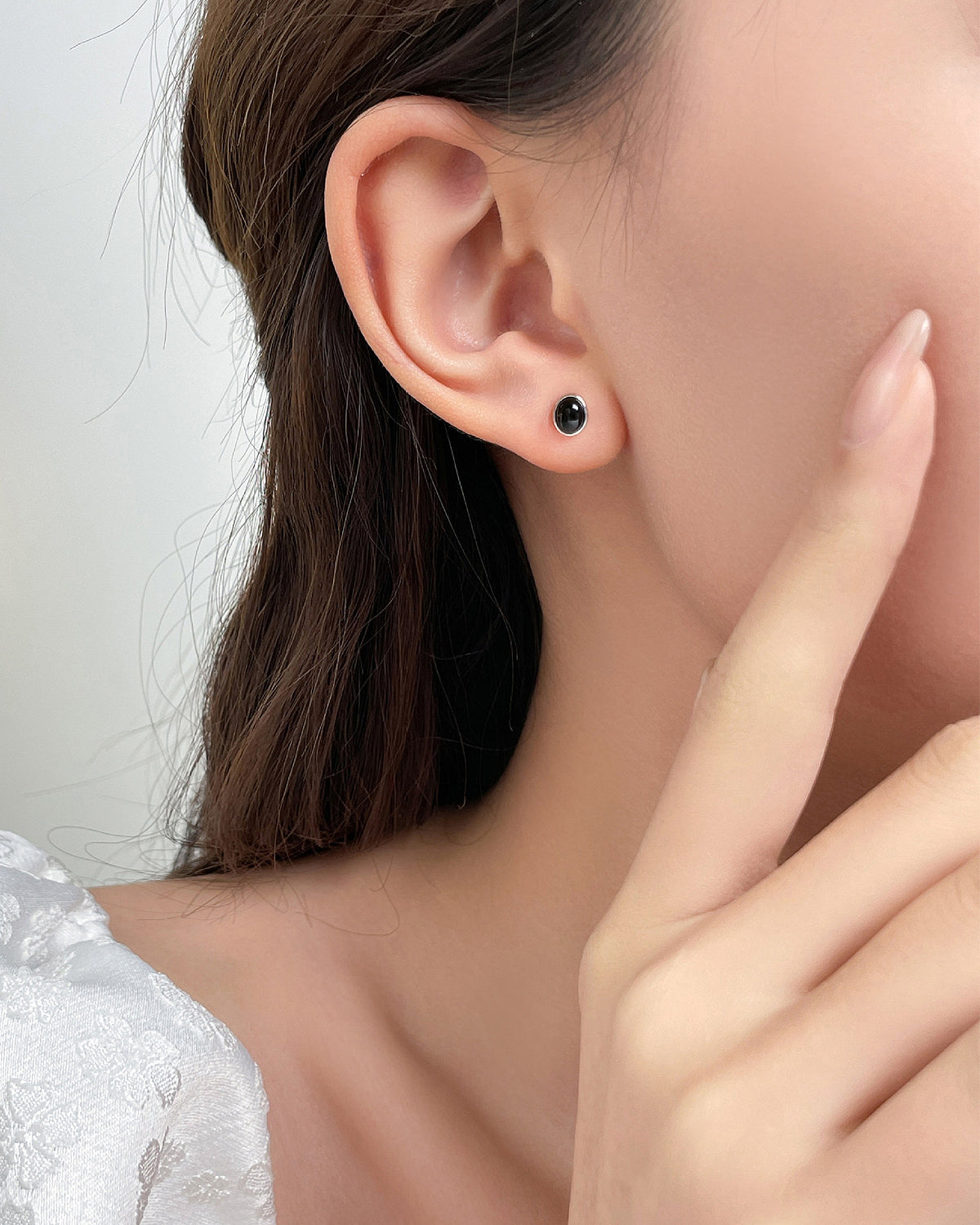 Black onyx oval stud earrings on the model