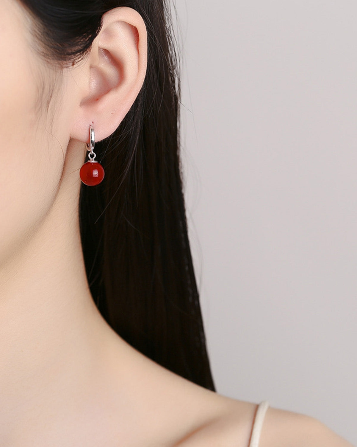 Red Agate Charm Huggie Hoop Earrings on the model