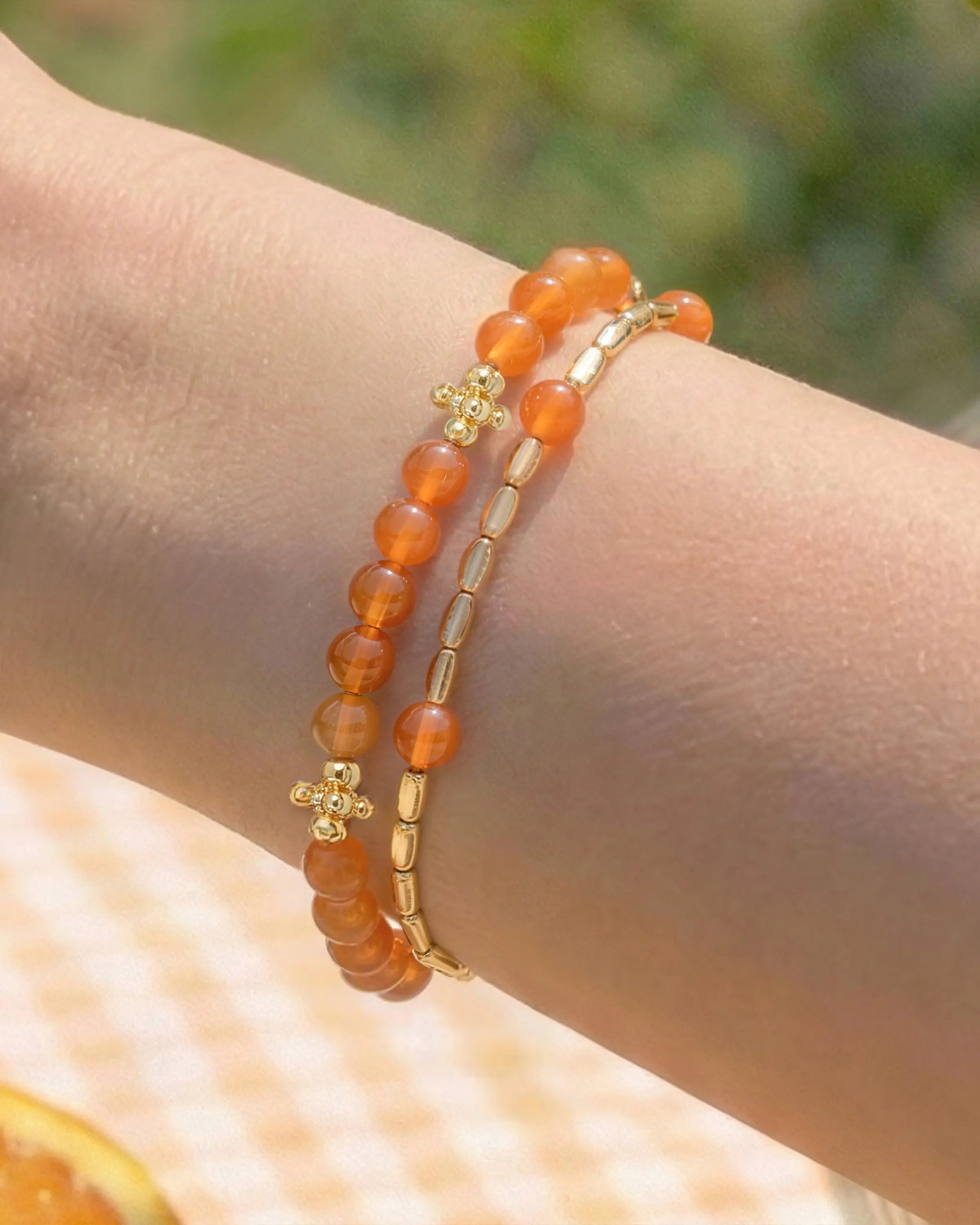 Detail of Orange Agate Gold Floral pre-layered bracelet on the model's wrist