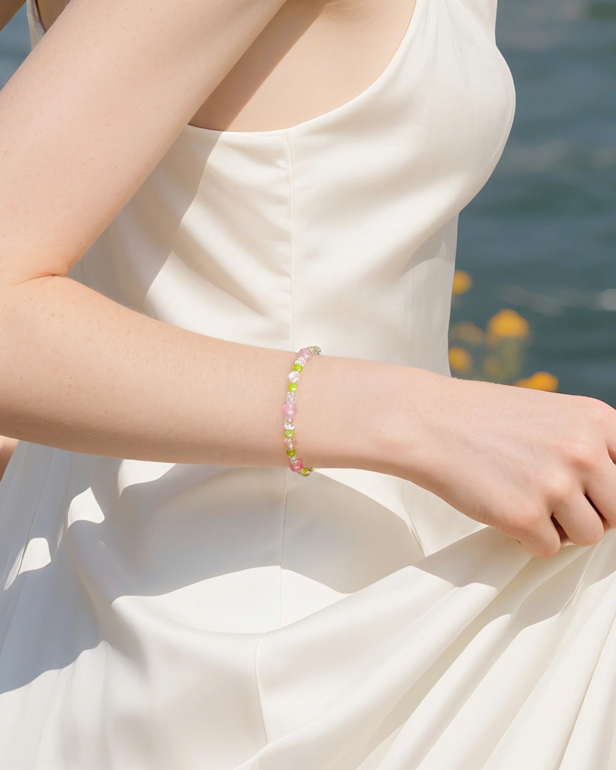 model wearing peridot beaded bracelet with clear quartz & rhodonite