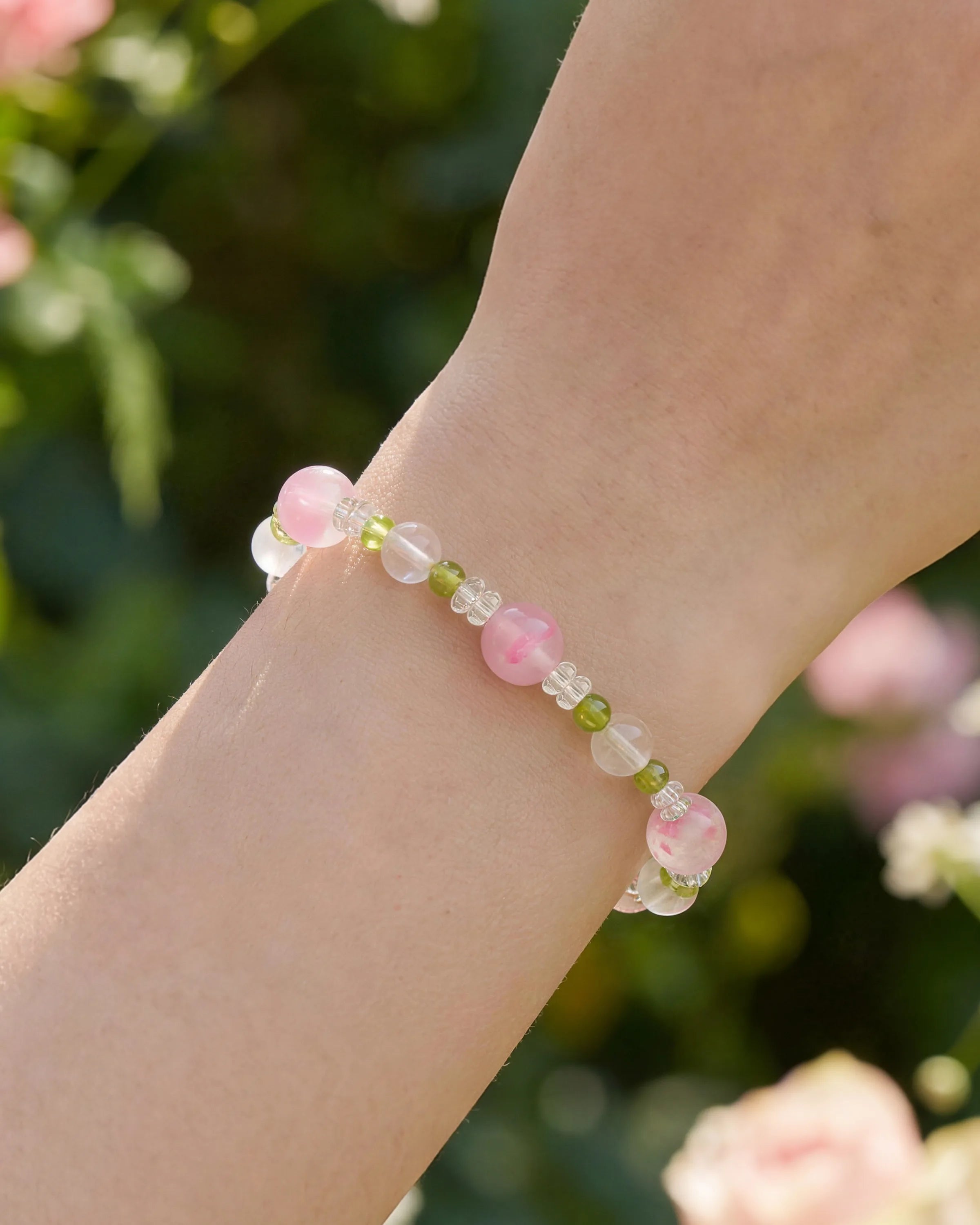 model wearing peridot beaded bracelet with clear quartz & rhodonite